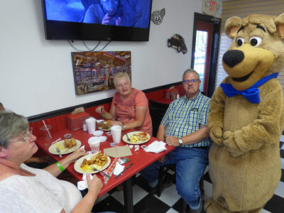 Boo Boo Bear Dining Experience at Cartoon Café – Jellystone Park™ South Haven Family dining with Boo Boo Bear inside the Cartoon Café at Jellystone Park South Haven